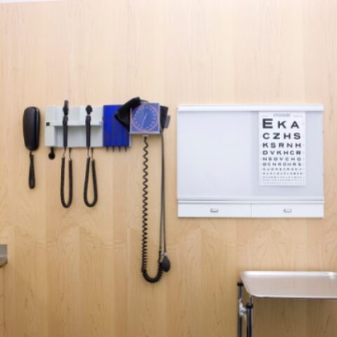 A doctor's room with blood pressure cuff, stethoscope and ear examiner.